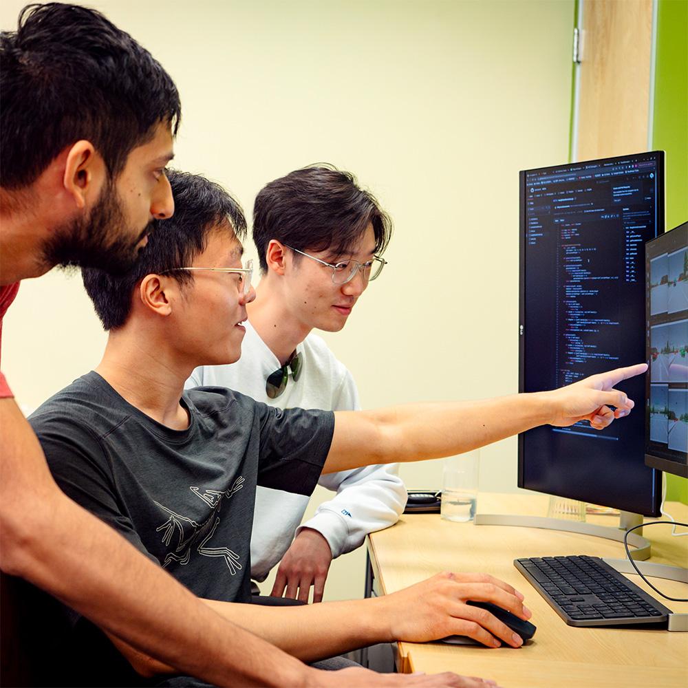 Students point at computer screen